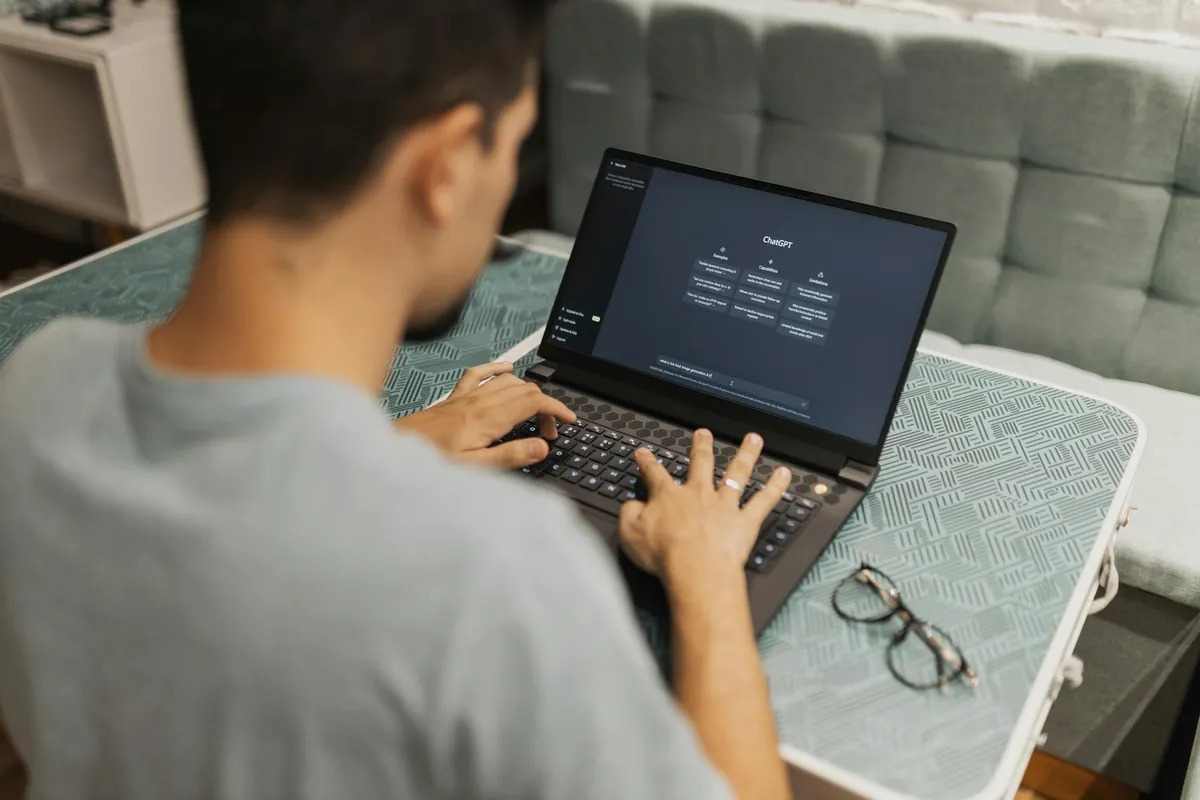 Homem digitando em um notebook com a tela inicial do ChatGPT aberta
