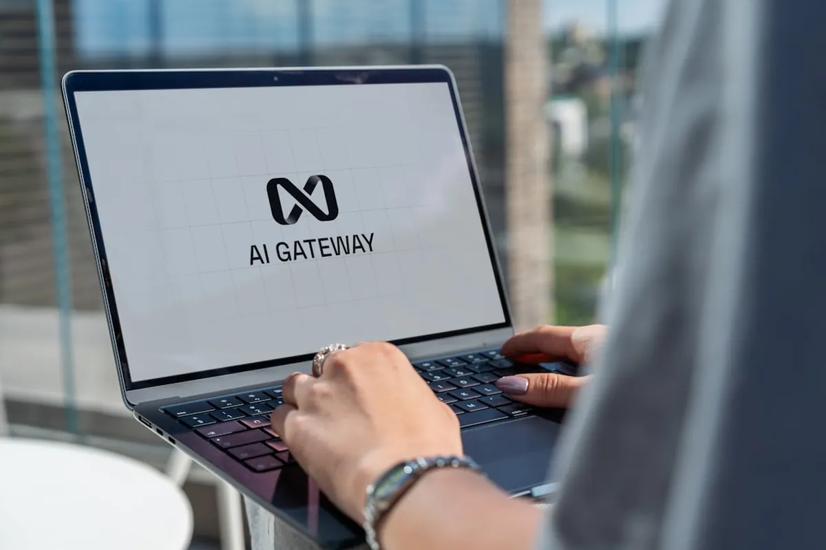 Mãos digitando em um notebook que exibe na tela a inscrição AI Gateway