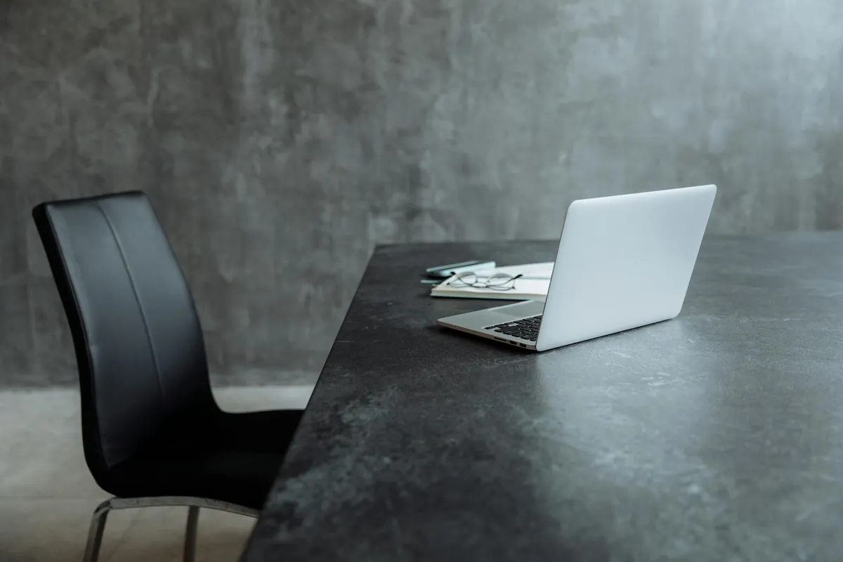 Mesa de trabalho com notebook aberto e anotações ao lado