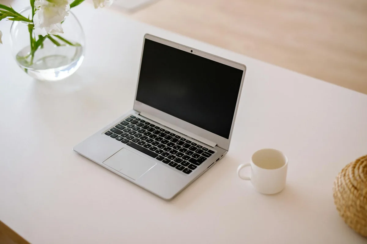 Notebook aberto sobre mesa clara, em ambiente de escritório